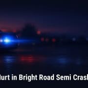 Fostoria News Police car lights flashing during night accident scene on dark road.